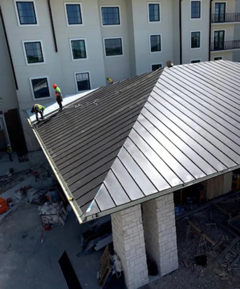 Crew installing standing seam metal roof panels on a commercial project in Fountain Valley